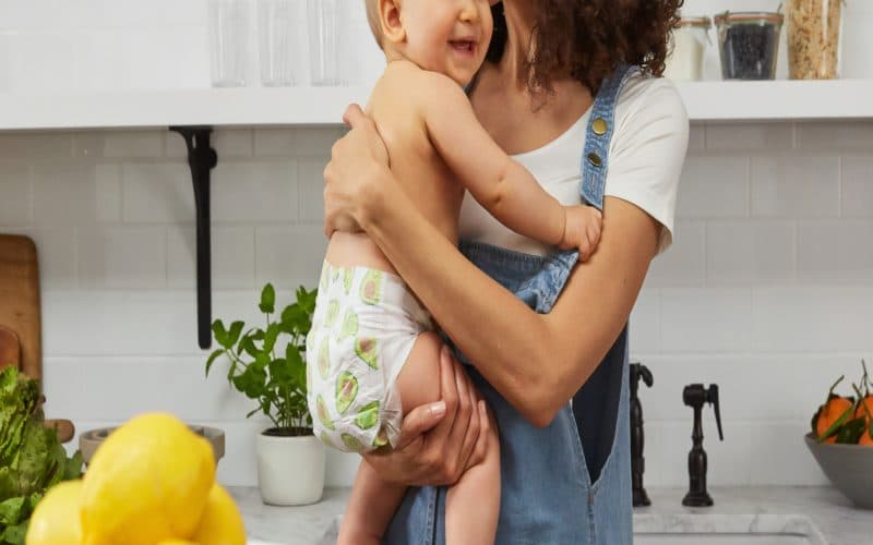 Kuva äidistä ja nauravasta lapsesta keittiössä
