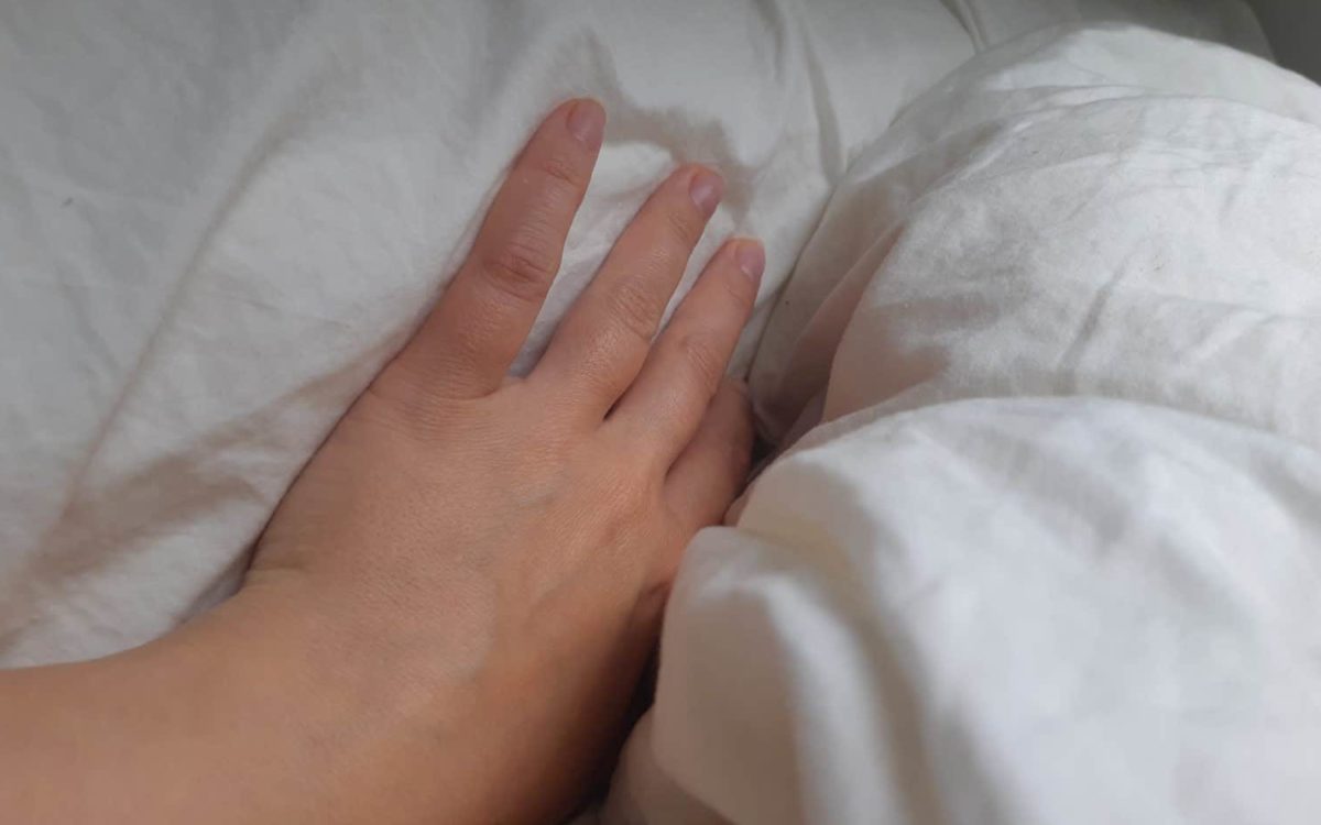 käsi sängyssä
