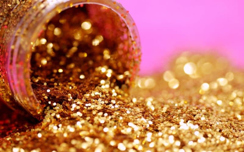 kultaista glitteriä vaaleanpunaisella taustalla