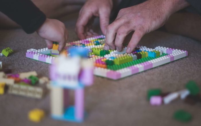 Aikuinen ja lapsi rakentamassa legoja