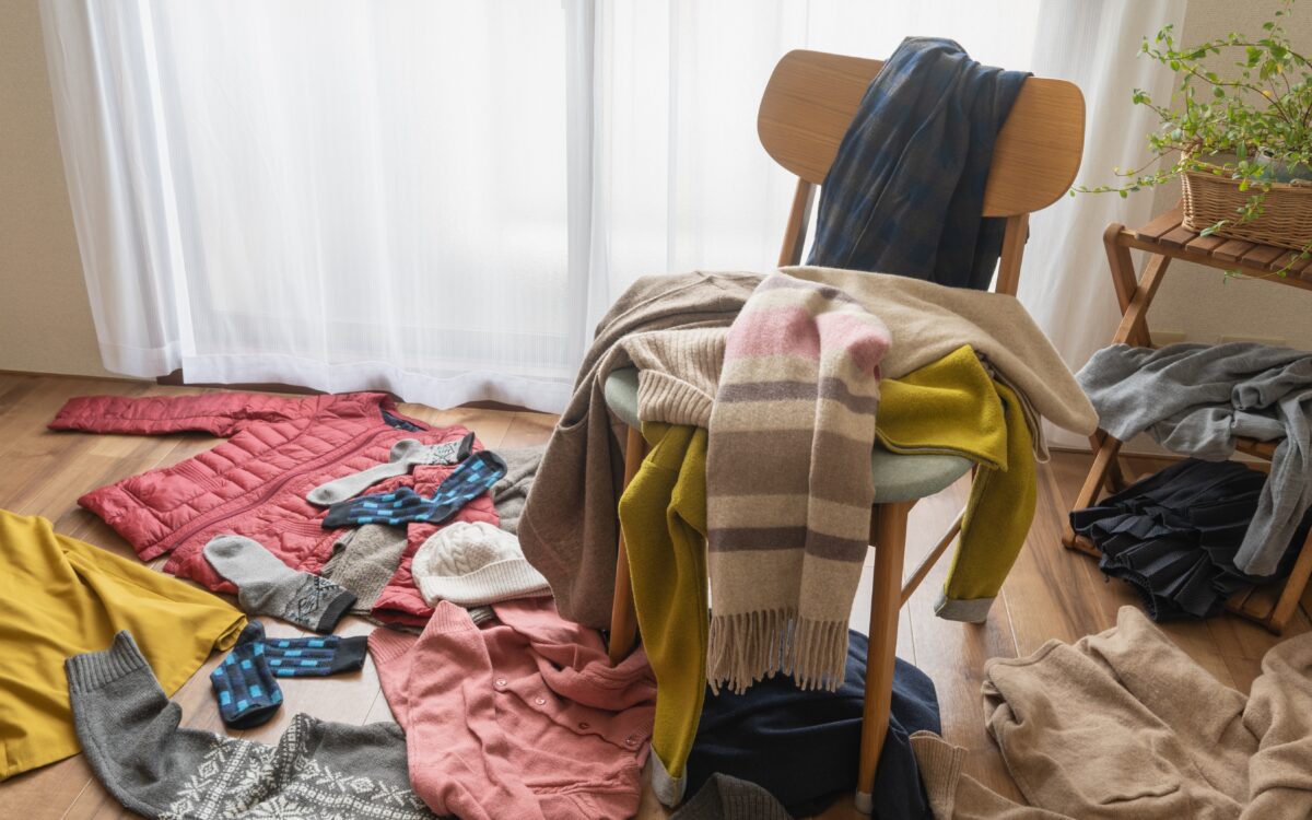 Epämääräinen kasa vaatteita heitettynä lattialle sekä tuolin päälle joka puolelle